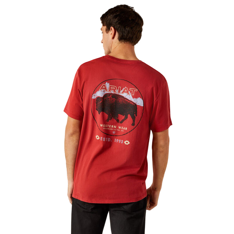 Person wearing a red Ariat t-shirt with a graphic design on the back against a beige background